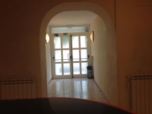 un couloir avec une porte voûtée dans un bâtiment dans l'établissement Hotel Belforte, à Varèse