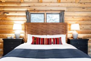 a bedroom with a bed with two night stands and two lamps at Iconic Log Cabin Escape - Idaho Springs - Hot Tub in Idaho Springs