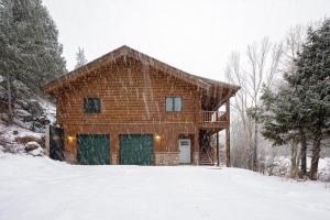 a log cabin in the snow with a porch at Iconic Log Cabin Escape - Idaho Springs - Hot Tub in Idaho Springs