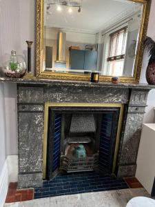 a fireplace with a mirror on top of it at Central London Apartment (1) in London
