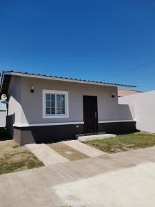 a small house with a black door in a driveway at Apartamento full en David, Chiriquí. 