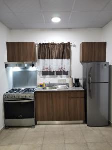 a kitchen with a stove and a refrigerator at Apartamento full en David, Chiriquí. 