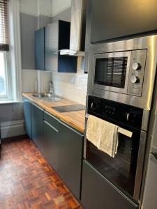 a kitchen with a stove with a microwave at Central London Apartment (1) in London