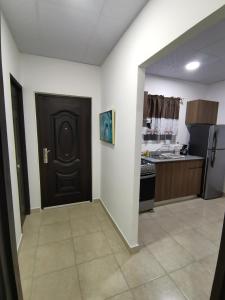 a kitchen with a black door in a room at Apartamento full en David, Chiriquí. 