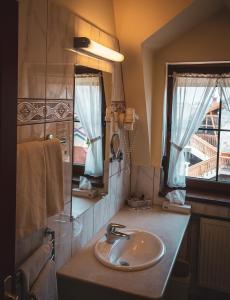 a bathroom with a sink and a mirror at Hétkúti Wellness Hotel in Mór