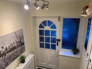 een badkamer met een witte deur en een raam bij Contractor & Family Friendly House Romford in Havering atte Bower +22 foto's