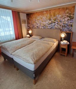 1 dormitorio con 1 cama grande y una pintura en la pared en B & B Gästehaus Schmidt en Lichtenberg