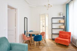 ein Wohnzimmer mit einem Tisch und Stühlen in der Unterkunft Très cosy 45m2, proche du parc des expositions in Paris