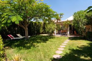 un patio con un árbol y algunas sillas y una casa en Bungalow Melocotones Maspalomas Golf, en Maspalomas