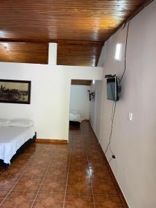 um quarto com uma cama e uma televisão num quarto em HOTEL CAMPESTRE REFUGIO TEXANO em Puerto Triunfo