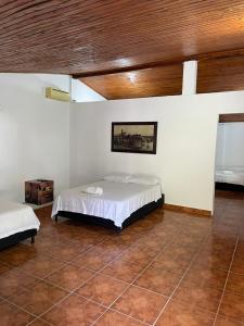 um quarto com 2 camas e um tecto de madeira em HOTEL CAMPESTRE REFUGIO TEXANO em Puerto Triunfo