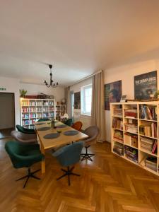 a living room with a table and chairs and bookshelves at Miło mi in Karpacz