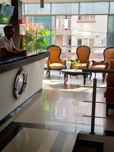 un hombre sentado en un escritorio en una sala de espera en HOTEL LONDRES PLAZA, en Pitalito