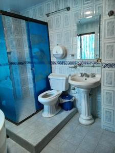 a bathroom with a toilet and a sink and a shower at HOTEL LONDRES PLAZA in Pitalito