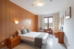 pokój hotelowy z łóżkiem, stołem i krzesłami w obiekcie Hotel Alda Ciudad de Toro w mieście Toro
