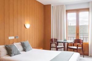 pokój hotelowy z łóżkiem i stołem z krzesłami w obiekcie Hotel Alda Ciudad de Toro w mieście Toro