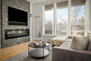 a living room with a couch and a tv at Chic City Park Home - Rooftop Deck - Skyline Views in Denver