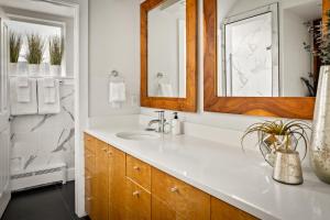 a bathroom with a sink and a mirror at Chic City Park Home - Rooftop Deck - Skyline Views in Denver +52 photos