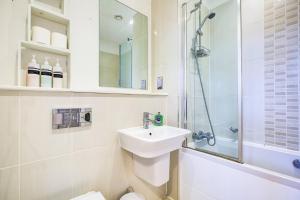 a white bathroom with a sink and a shower at Pass the Keys Cosy flat in Chelmsford in Chelmsford
