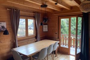 a dining room with a wooden table and chairs at Savoyard nest with Mont Blanc view in Flumet