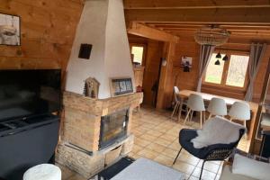 a living room with a fireplace in a log cabin at Savoyard nest with Mont Blanc view in Flumet