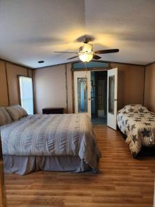 a bedroom with two beds and a ceiling fan at The Holler Inn at Dale Hollow in Frogue