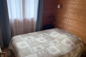 a bedroom with a white bed with a wooden wall at Savoyard nest with Mont Blanc view in Flumet