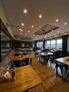 a restaurant with wooden tables and chairs and windows at Miło mi in Karpacz