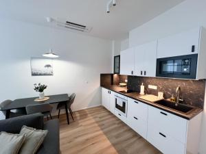 a kitchen and living room with a table and a couch at Rezidence BLUM in Brno