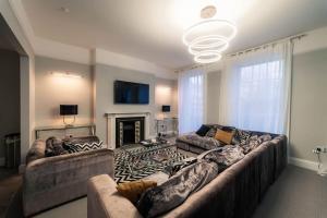 a living room with a large couch and a fireplace at 3 The Steyne - Stunning 5 Storey Georgian house with cinema room in Worthing