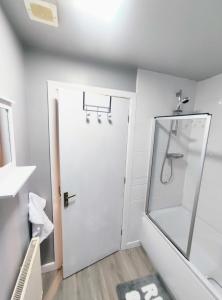 a bathroom with a shower and a glass door at High Rigg House Bradford - Luxury Accomodation with Private Parking in Idle