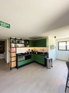 a kitchen with green cabinets and a counter top at Liiv Costeira - Natal Ponta Negra in Natal