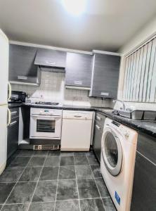 a kitchen with a washing machine and a washer at High Rigg House Bradford - Luxury Accomodation with Private Parking in Idle