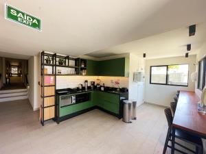 uma cozinha com armários verdes e uma bancada em Liiv Costeira - Natal Ponta Negra em Natal