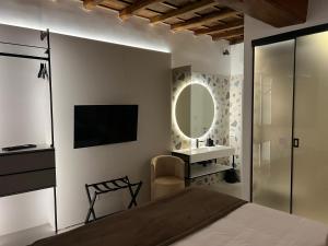 a bedroom with a bed and a mirror and a television at Affreschi al Pantheon in Rome