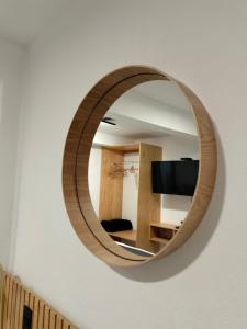 a round wooden mirror hanging on a wall at CHOLULA SUITES in Cholula