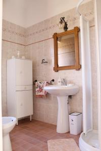 un bagno con lavandino, water e specchio di Villa Anna a San Venanzo