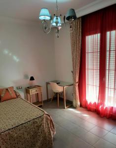 1 dormitorio con cama, mesa y ventanas en Casa Pablo Picasso 9, en Jimena de la Frontera