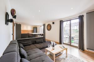 a living room with a couch and a table at Logement chaleureux haut de gamme dans le Trièves - WIFI - NETFLIX in Clelles