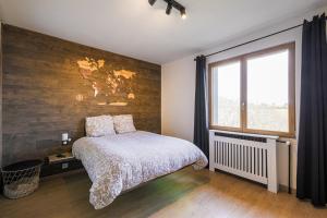 a bedroom with a bed and a large window at Logement chaleureux haut de gamme dans le Trièves - WIFI - NETFLIX in Clelles