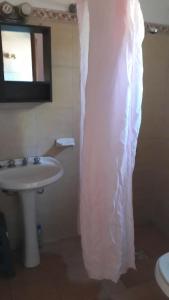 La salle de bains est pourvue d'un lavabo et d'un rideau de douche blanc. dans l'établissement Alquileres en Piriápolis Coriman & Luz de Luna, à Piriápolis