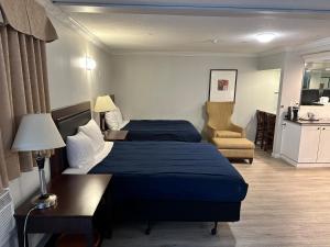 une chambre d'hôtel avec deux lits et une chaise dans l'établissement Travelodge by Wyndham Langley, à Langley
