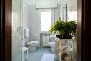 ein weißes Bad mit einem WC und einem Fenster in der Unterkunft Venice Green Lagoon - 20 min da Venezia in Mestre