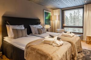 a bedroom with two beds with towels on them at Jänkä Penthouse in Levi