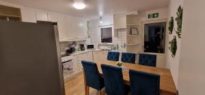 a kitchen with a wooden table and blue chairs at Central Peaceful Villa, Malmö in Malmö