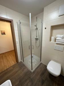 a bathroom with a glass shower and a toilet at Apartment - Pension Marianna in Rust