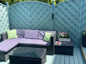a purple couch and a table on a patio at The Mirador Boutique Town House in Swansea