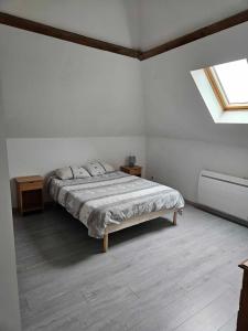 Habitación blanca con cama y ventana en Gite esprit loft en Fromelles