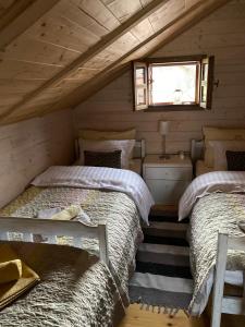 Duas camas num pequeno quarto com uma janela em Kuca Dide Juke pod Lipovcem em Gospić