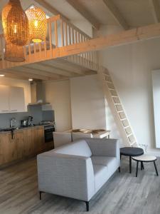 een woonkamer met een bank en een loft bij Eb en Vloed Katwijk in Katwijk